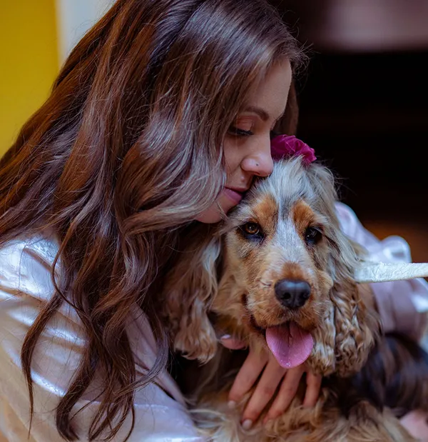 A bride, getting dressed on her wedding day, takes time out to cuddle her best friend - her dog