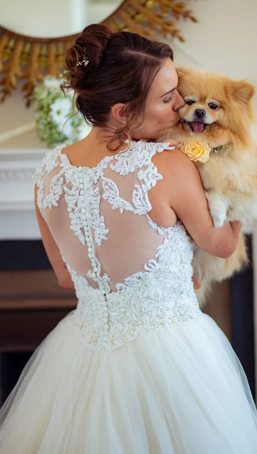 The bride picks up her dog at her wedding to give it a cuddle and big kiss!